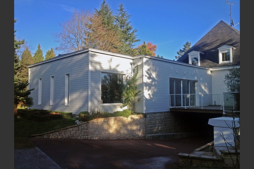 Extension bois cubique  l'arrire d'une maison traditionnelle en partie sur terrasse